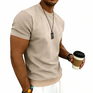Dettaglio ravvicinato di una t-shirt beige da uomo con trama a nido d'ape e scollo rotondo