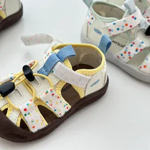 Vista detallada de sandalias para bebé con puntos de colores y prácticos cierres de velcro