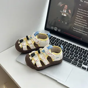 Detalle de sandalias de verano para bebé con lunares de colores y diseño de punta cerrada