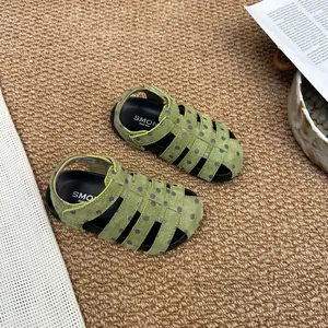 Nahaufnahme von grünen gepunkteten römischen Sandalen für Mädchen mit weicher Sohle.