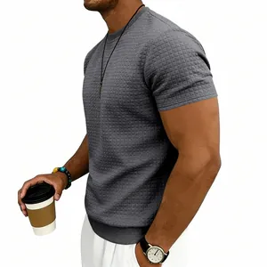 Dettaglio di una t-shirt a maniche corte grigio scuro da uomo con texture a nido d'ape e girocollo
