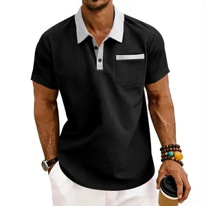 Detail of black waffle knit polo shirt with grey contrast collar and chest pocket.