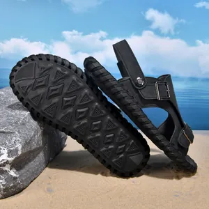 Close-up detail of men's black leather beach sandals focusing on the non-slip rubber sole texture
