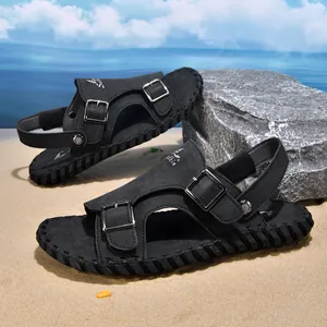 Professional men's black leather beach sandals with adjustable metal buckles on sand