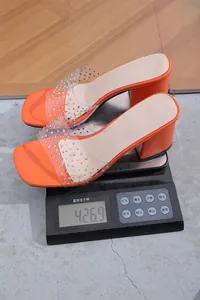 Detail showing weight measurement of 426.9g for orange rhinestone block heel sandals