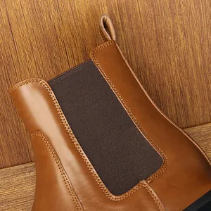 Dettaglio ravvicinato dello stivale Chelsea marrone con cuciture e fascia elastica.