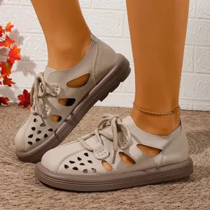 Nahaufnahme beiger Vintage-Sandalen mit Lochmuster, Schnürung und geschlossener Zehenpartie