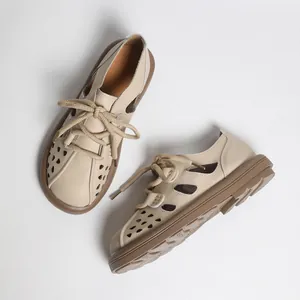 Detaillierte Draufsicht auf beige Retro-Hohllochsandalen mit brauner weicher Sohle und Schnürsenkeln