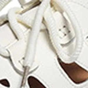 Makro-Detail des atmungsaktiven Lochmusters und der Schnürsenkel weißer Sandalen.