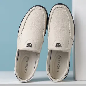 Vue verticale de mocassins en cuir blanc montrant le grain et le logo de la marque à l'intérieur