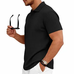 Vue de côté d'un polo en maille jacquard noire pour homme montrant la texture du tissu