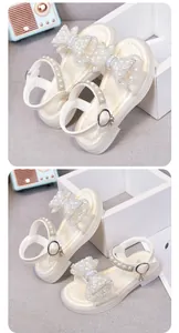 Detailansicht der eleganten cremefarbenen Mädchensandalen mit Perlschleife und Antirutschsohle