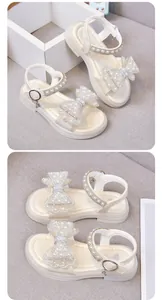 Elegante weiße Mädchensandalen mit einer perlenbesetzten Schleife und Strassriemen