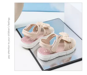 Detalle de sandalias beige para niñas con decoración de lazo y diamantes de imitación