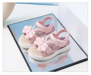Detalle de las sandalias rosas para niña con lazo decorativo y pedrería fina