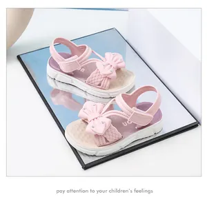 Primer plano de sandalias rosas para niña con lazo lindo y suela blanda