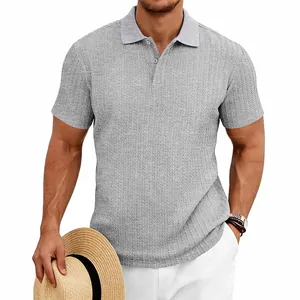 Détail en gros plan montrant la texture jacquard en maille grise de ce polo pour hommes