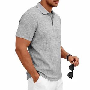 Gros plan d'un polo gris pour homme montrant une texture jacquard en maille torsadée.