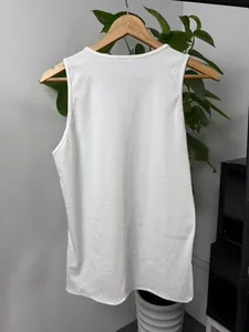 Vue arrière du débardeur côtelé blanc ajusté pour hommes sur un cintre en bois.