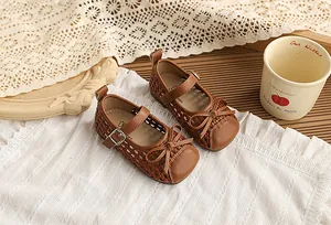 Detalle de zapatos Mary Jane trenzados en color marrón con lazo para niñas pequeñas
