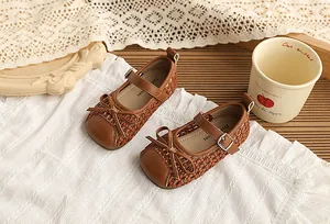 Primer plano de zapatos Mary Jane trenzados marrones para niña con un lazo