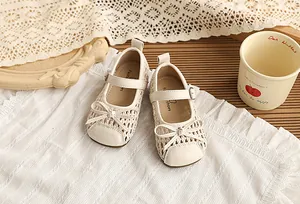 Detalle del diseño tejido y el lazo en las sandalias beige de princesa para niñas