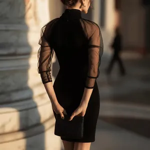 Detalle de vestido negro elegante con cuello alto y mangas largas de malla transparente