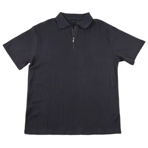 Detail of a men's knit textured polo shirt with a half-zipper closure in charcoal.