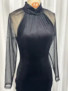 Detalle de primer plano de un elegante vestido negro con cuello alto y mangas de malla