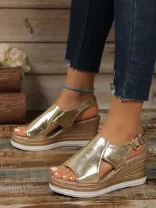 Close-up detail of gold metallic peep-toe wedge sandals featuring a stylish platform heel.