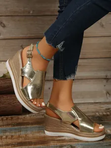 Close-up of gold metallic wedge sandals with hollow fish mouth design.
