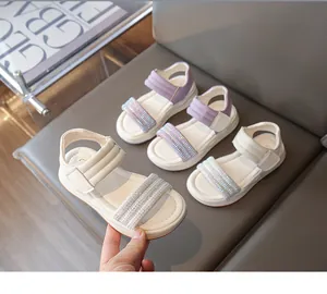 Detailansicht der Mädchensandalen mit glitzernden Strassriemen und weißen Sohlen