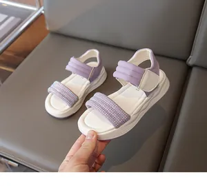 Nahaufnahme violetter Mädchensandalen mit glitzerndem Strassriemen und Polsterung