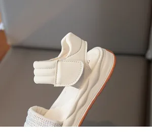 Detailansicht der stylischen beigen Mädchensandale mit Strass und Klettverschluss.