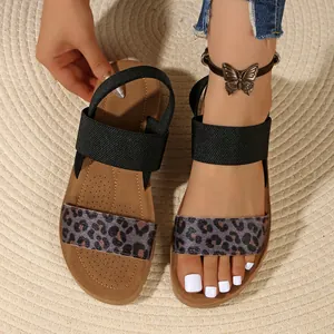 Dettaglio ravvicinato di sandali leopardati da donna con comodi cinturini elastici neri