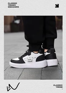 Detailed side view of classic black and white kids' sneakers featuring 'Fashion' label
