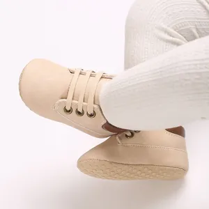 Close-up of beige soft-sole PU baby walker shoes with lace-up design