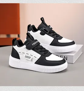 Side view of children's black and white sneakers with Velcro straps and classic design