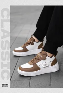 Detail showing children's classic brown and white casual sneakers worn on feet
