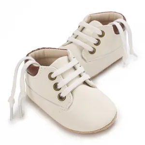 Close-up shot of soft cream baby walking shoes featuring brown heel and white laces