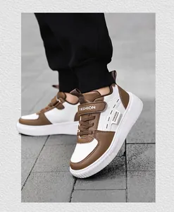 Close-up on-feet view of brown and white kids' casual sneakers with 'FASHION' strap details