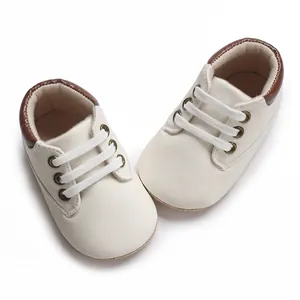 Close-up view of soft cream baby walking sneakers with brown trim for infants.
