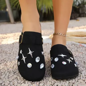 Detail shot of black clogs featuring sparkling star and oval rhinestone embellishments.