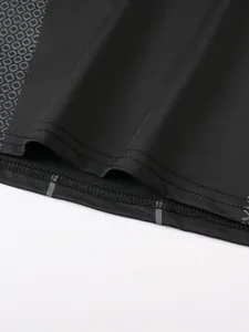 Close-up detail of reinforced stitching and honeycomb fabric on a black compression shirt
