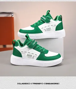 Side view of stylish green and white kids sneakers with velcro straps and thick soles