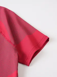 Close-up detail of red compression t-shirt sleeve showing stitching and honeycomb pattern