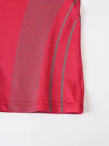 Close-up of red compression t-shirt fabric with gray honeycomb and stripe patterns