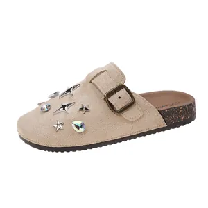 Side view detail of beige suede closed-toe mule with star studs and buckle