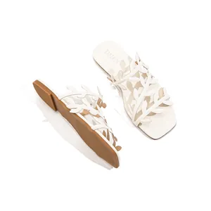 Stylish white flat sandals featuring unique leaf pattern straps for summer beach holidays