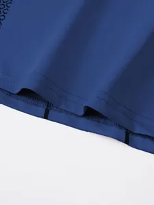Close-up of durable double-stitched hem on blue men's athletic compression t-shirt.